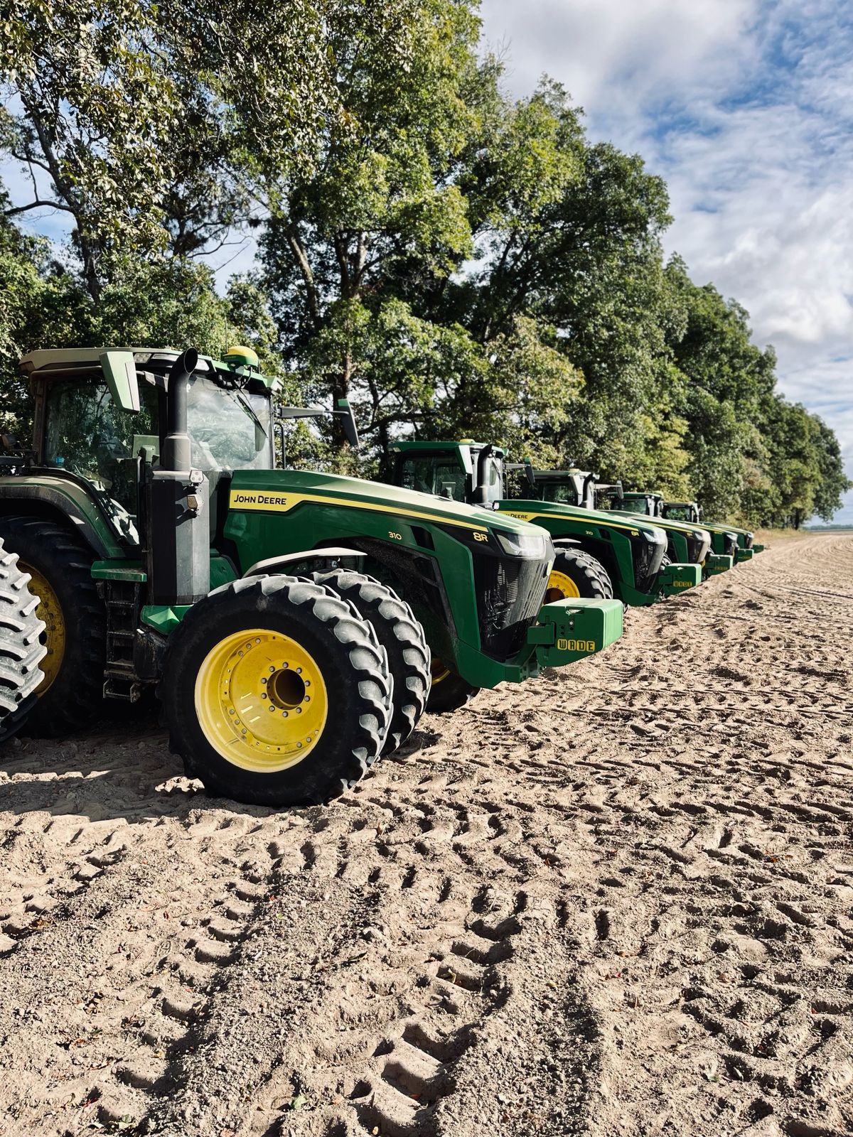 Fleet of tractors lined up at the edge of a field